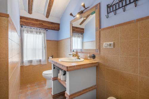 a bathroom with a sink and a toilet and a mirror at Romero in Hinojares