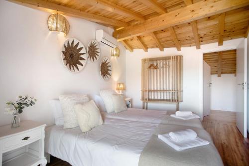ein Schlafzimmer mit einem weißen Bett und einer Holzdecke in der Unterkunft Vila River Sublime in Valada