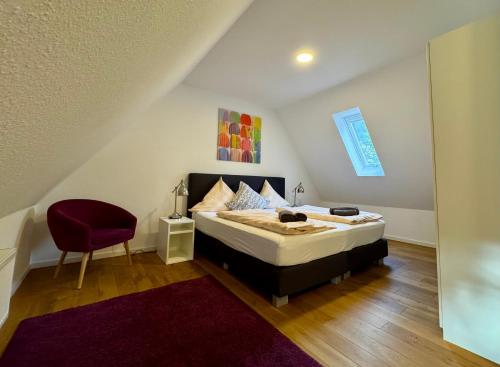 a bedroom with a bed and a red chair at Gut Wenne in Eslohe