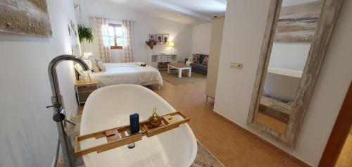 a bathroom with a sink and a bed and a tub at Casa s’Hort - Can Rita in Llombarts