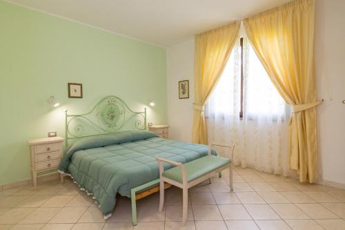 a bedroom with a green bed and a window at Il Girasole - Corbezzolo in Venturina Terme