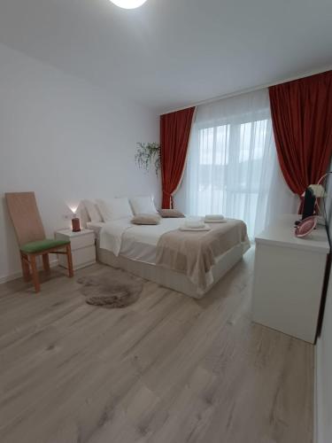 a bedroom with a large bed and red curtains at Cazare Rasnov cu vedere spre Postavaru in Râşnov