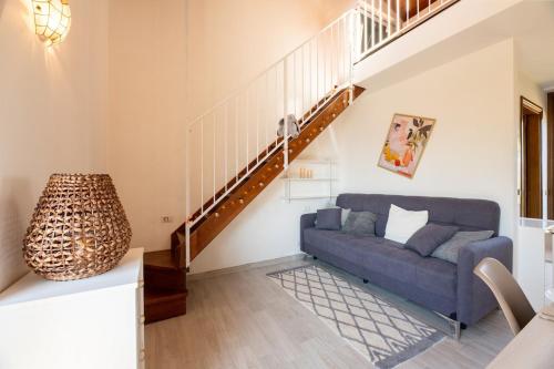 a living room with a blue couch and a staircase at Begna Kiddie Paradise Poolside Retreat in Porlezza