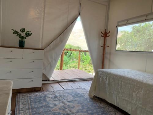 a bedroom with a bed and a dresser and a window at casa glamping in Lunahuaná