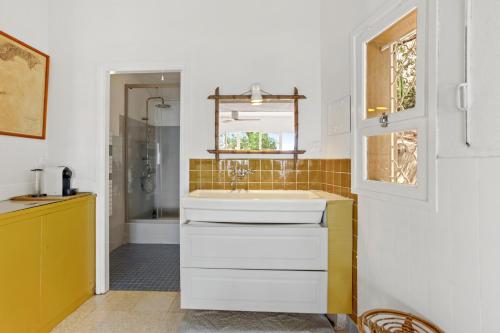 a white bathroom with a sink and a window at Chambres d'hôtes - La Moustelle in La Croix-Valmer