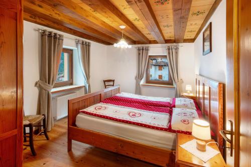 a bedroom with a bed and a wooden ceiling at Appartamento Zopel in Falcade