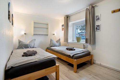 a bedroom with two beds and a window at Bäckerhus - Ferienwohnung 2 in Wiek auf Rügen