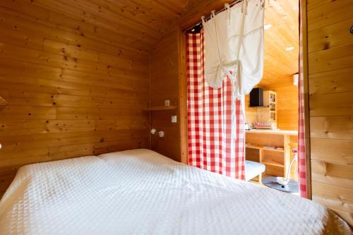 a bedroom with a bed in a wooden room at Tiny House, Clim et Bassin in Auriac-du-Périgord