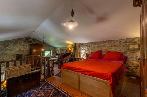 a bedroom with a bed in a stone wall at Villa L'Elzède in Les Vans