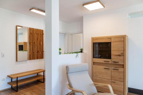 a room with a chair and a desk and a mirror at Manu's Bergblick in Arzl im Pitztal