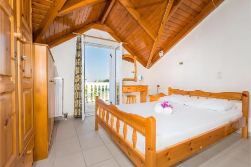 a bedroom with a large bed with a wooden ceiling at Tamar Apartments, Laganas in Laganas