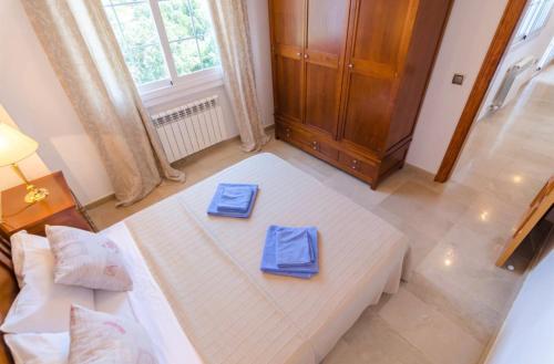 a bedroom with a large white bed with two blue napkins at Villa Mansory in Lloret de Mar
