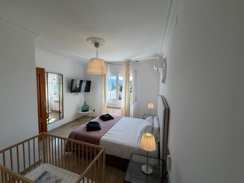 a bedroom with a bed in a room with a balcony at Villa Mansory in Lloret de Mar