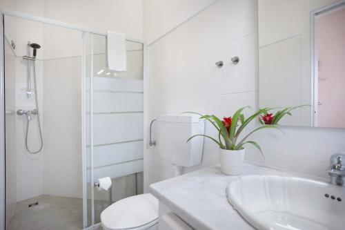 a white bathroom with a toilet and a sink at Páteo da Várzea 2 in Colares