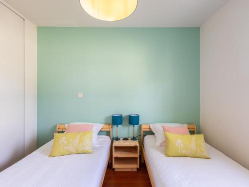 two beds in a room with blue and white walls at Pieds Dans L'eau Madame est Servie in Trébeurden
