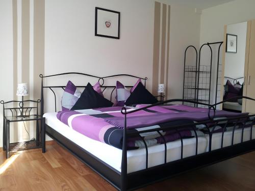 a bedroom with a bed with purple sheets and pillows at Ferienwohnung Poll in Wimbach