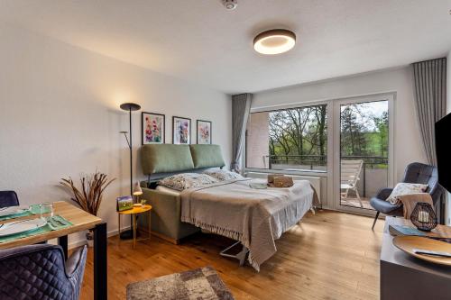 a bedroom with a bed and a large window at Berg und Tal Apartment in Brilon