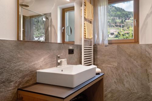 a bathroom with a white sink and a mirror at Baumannhof Villnöß in Funes