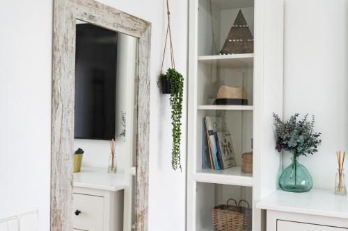 a mirror in a room with white shelves at Casa Ohana Fuengirola in Fuengirola