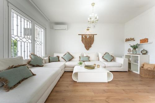 a white living room with a white couch and a table at Casa Ohana Fuengirola in Fuengirola