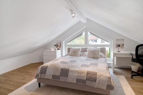 a white bedroom with a bed and a window at Fewo Christi in Weißensberg