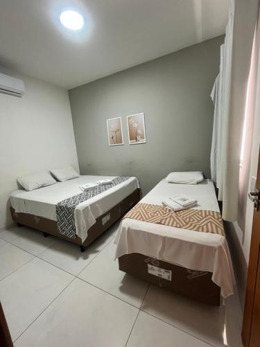 two beds in a small room with two bedsvisor at Modelo Prime Hotel in Ribas do Rio Pardo