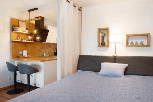 a small bedroom with a bed and a kitchen at Weitblick in Uhldingen-Mühlhofen