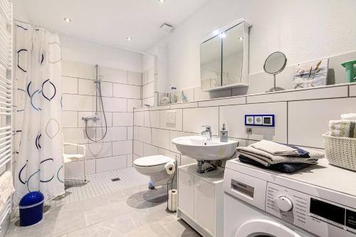 ein weißes Badezimmer mit Waschbecken und Toilette in der Unterkunft Traumland in Hollingstedt