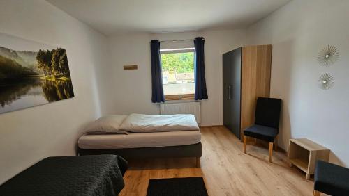 a bedroom with a bed and a window and a chair at wohnung-nummer-4 in Pielenhofen