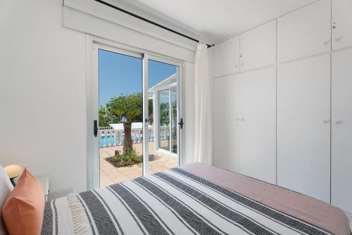 a bedroom with a bed and a sliding glass door at Villa Milena in Callao Salvaje