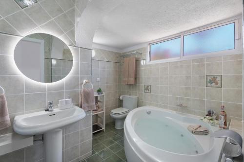 a bathroom with a tub and a sink and a toilet at Villa Milena in Callao Salvaje