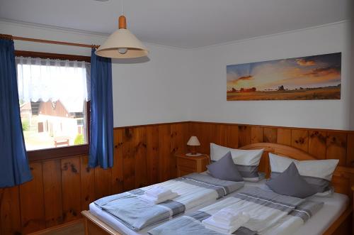 a bedroom with two beds with blue curtains and a window at Ferien Auf Dem Steingrubenhof in Sankt Peter