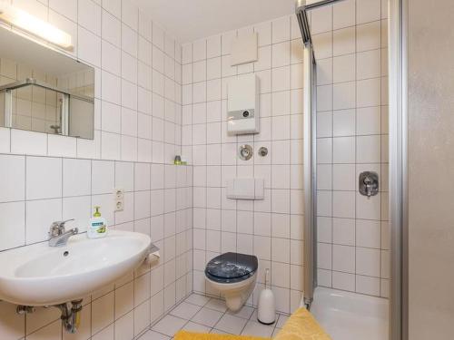a bathroom with a sink and a toilet and a shower at Haus Fanjak in Uhldingen-Mühlhofen