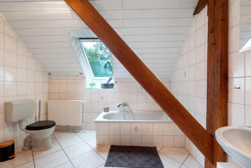a bathroom with a tub and a toilet and a sink at Grodenhof in Norderschwei