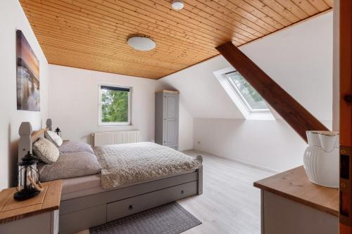 a bedroom with a bed and a wooden ceiling at Grodenhof in Norderschwei