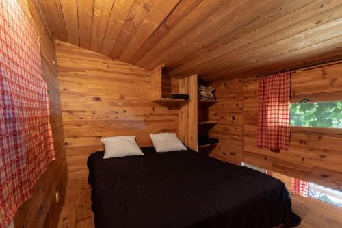 a bedroom with a bed in a log cabin at Petite maison de bois in Banyuls-dels-Aspres