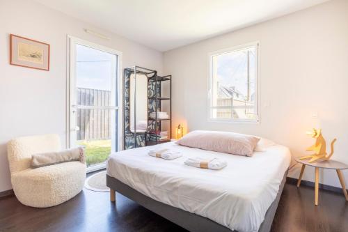 a bedroom with a bed and a chair and a window at Maison Horizon - 3 ch - 100m plage in Le Guilvinec