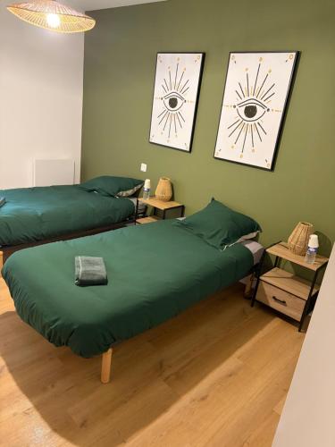two beds in a room with green walls at L auberge des marais proche Marennes Oléron in Saint-Just