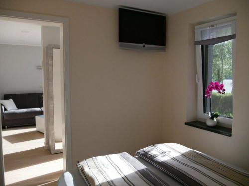 a living room with a flat screen tv on the wall at Am Kiefernweg 17 in Schwielochsee