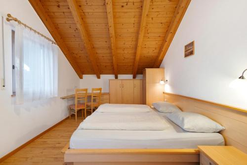 two beds in a room with a wooden ceiling at Residence Linderhof in Natz-Schabs