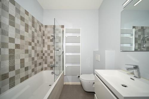 a bathroom with a toilet and a shower and a sink at Le Clos du Casino in Luchon