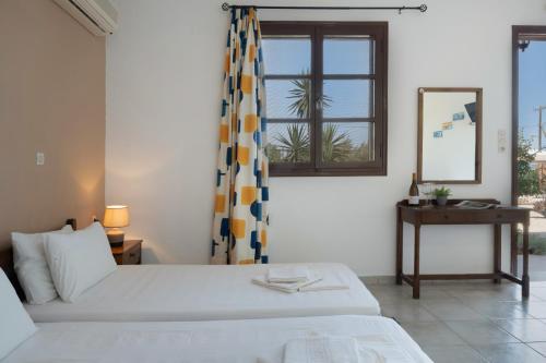 a bedroom with a bed and a window and a mirror at Frantzis Studio 2 - Nisyros in Páloi