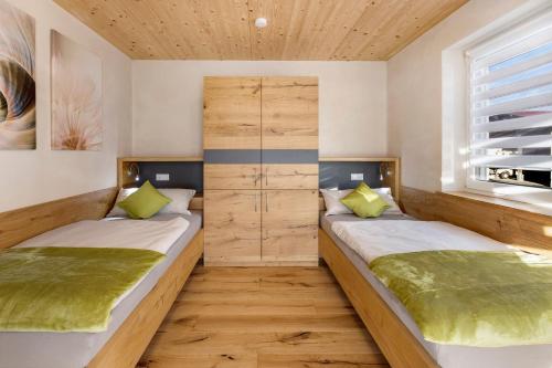 two beds in a room with wooden floors at Ferienwohnungen Bosserthof in Donaueschingen
