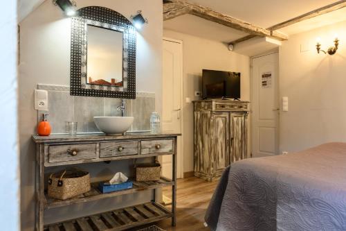 a bathroom with a sink and a bed in a room at Demeure D'antan - Chambres d'hôtes in Beblenheim