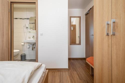 a bedroom with a bed and a bathroom at Gasthof Adler in Ebenweiler
