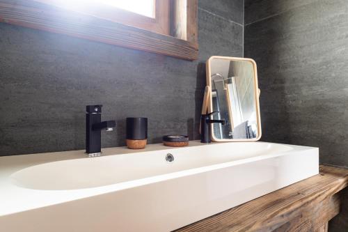 a bathroom with a white sink and a mirror at La cabane du cerf in Les Allues