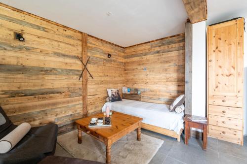 a room with a bed and a wooden wall at La cabane du cerf in Les Allues