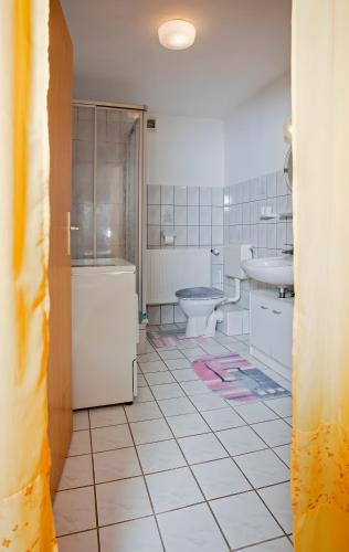 a bathroom with a toilet and a sink and a tub at Ferienhof Rosenwarft in Pellworm