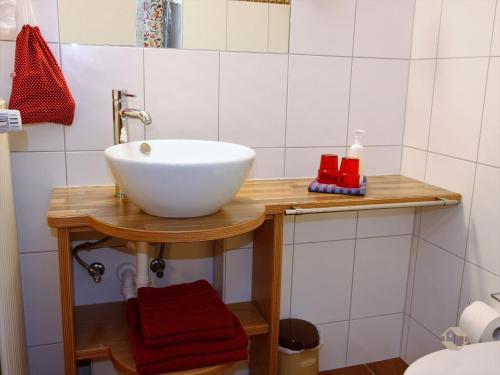 a bathroom with a white bowl sink on a wooden table at Erlenhof in Todtnau
