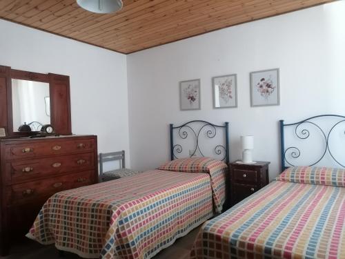a bedroom with two beds and a dresser at Casa vacanze Bau Mela in Villanova Strisaili